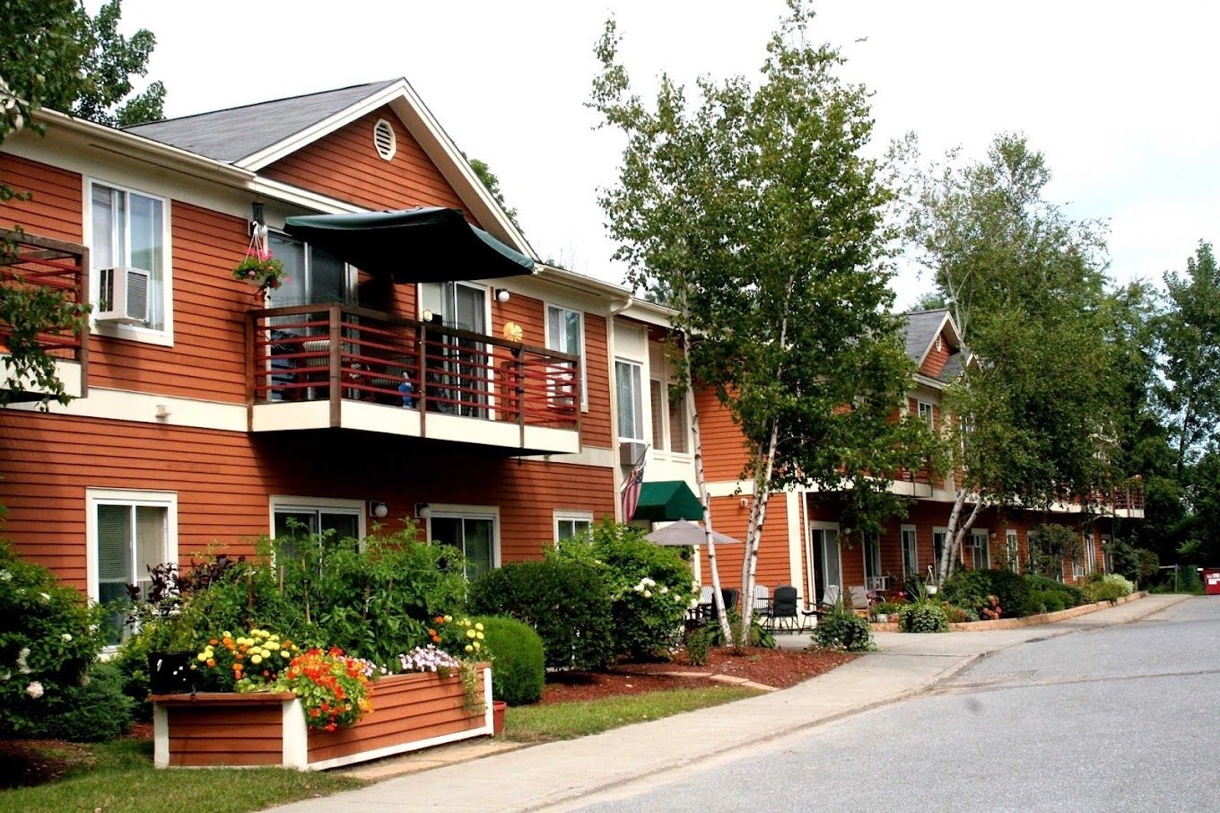 Well-maintained exterior of a senior living facility with colorful flowers