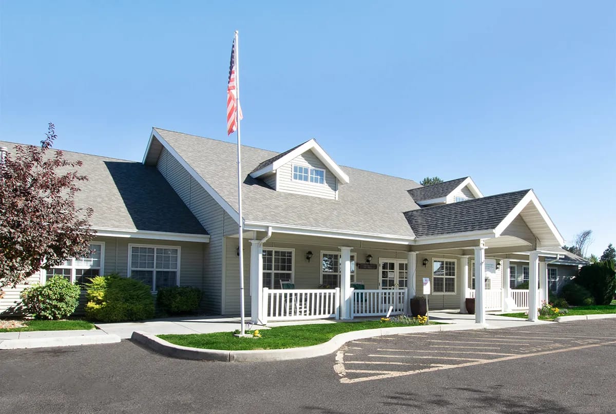 Exterior view of a senior living facility with American flag