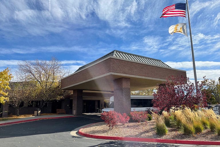Exterior view of Life Care Center of Aurora with autumn foliage
