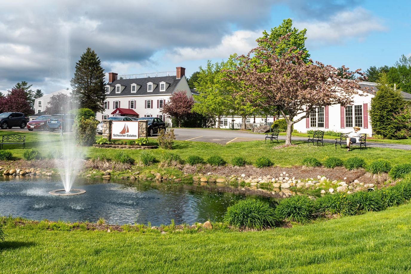 Exterior view of Schooner Estates with a fountain and garden