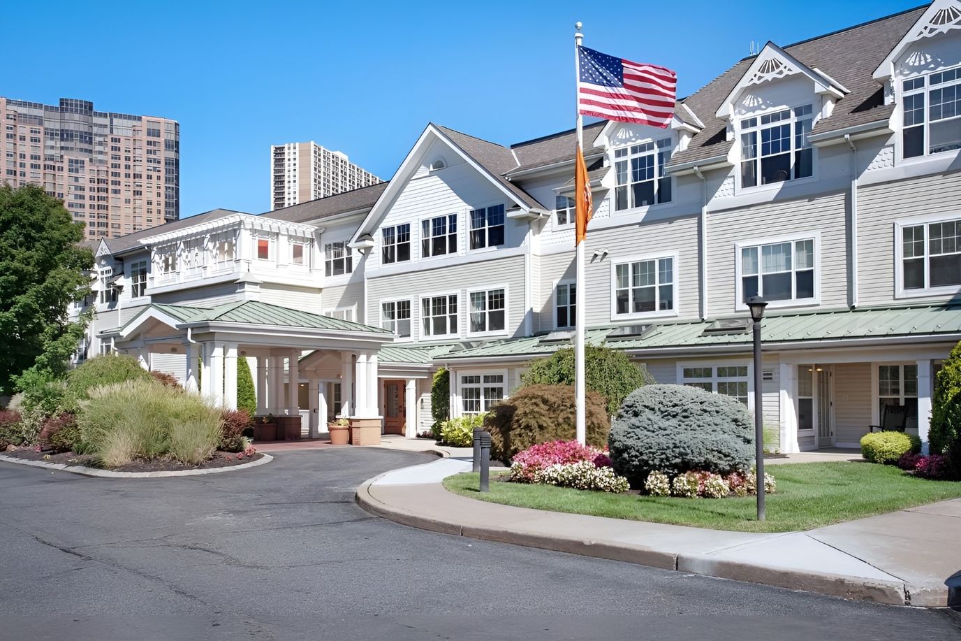 Exterior view of Sunrise of Edgewater with landscaping and flag