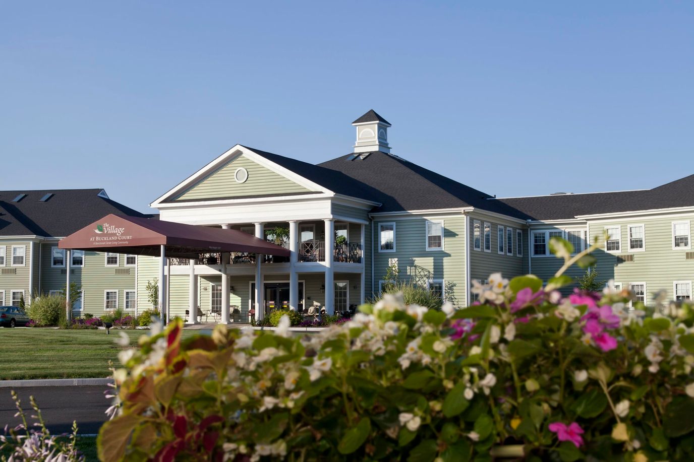 Exterior view of The Village at Buckland Court with flowers