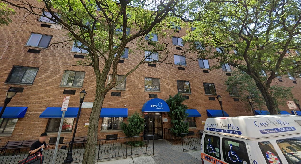 Exterior view of a senior living facility with blue awnings