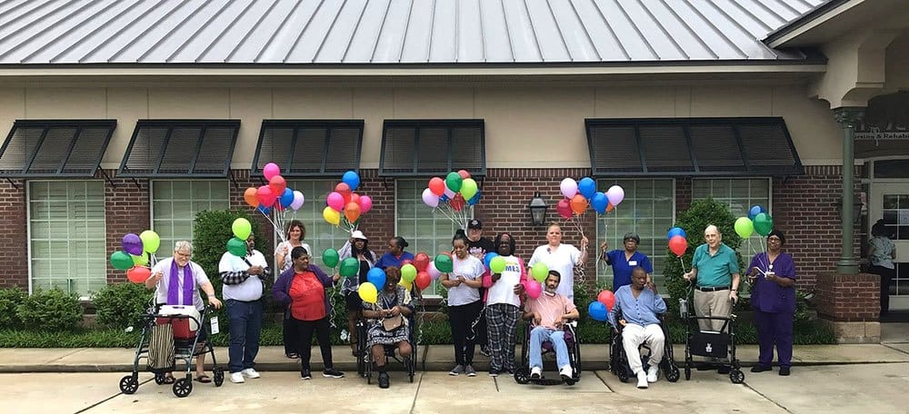 Residents celebrating outside with colorful balloons
