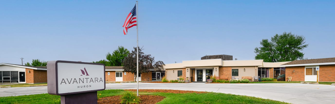 Exterior view of Avantara Huron facility with flag