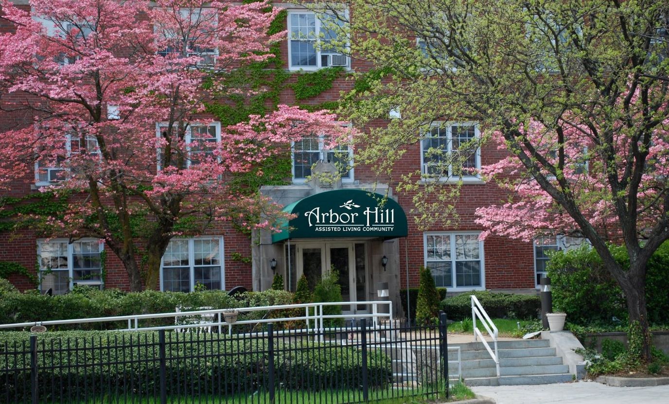 Exterior view of Arbor Hill Assisted Living with blooming trees