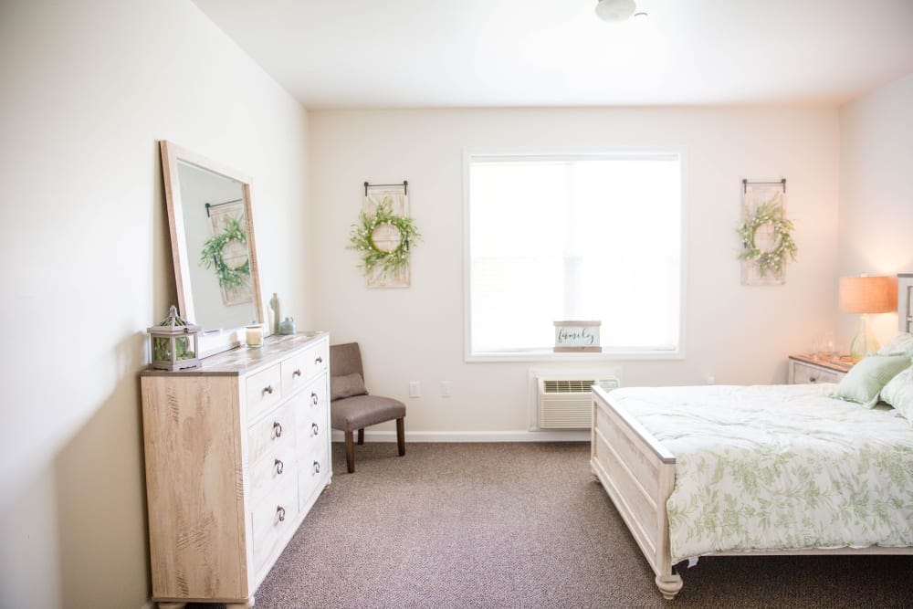 Bright and airy bedroom with a bed and dresser