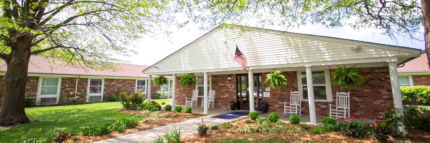 Front entrance of a senior living facility with rocking chairs