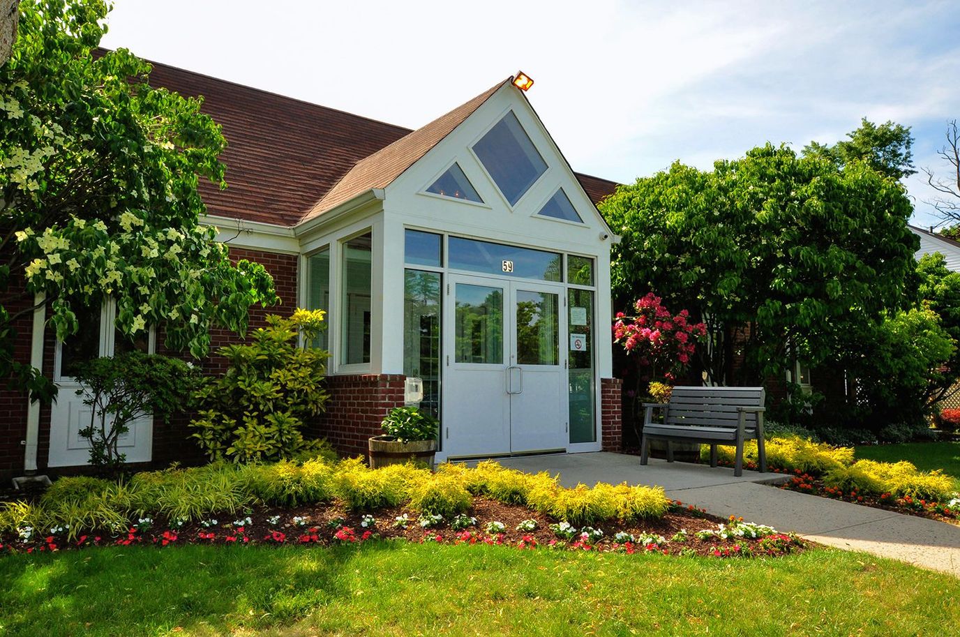 Entrance of a senior living facility with vibrant landscaping
