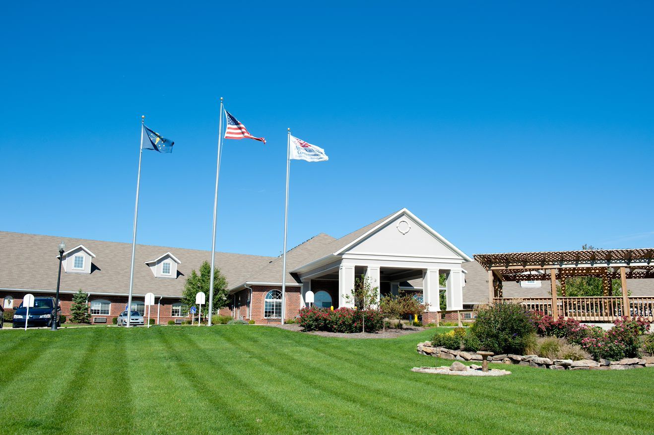 Entrance of Sage Bluff Health & Rehab Center with flags and landscaping