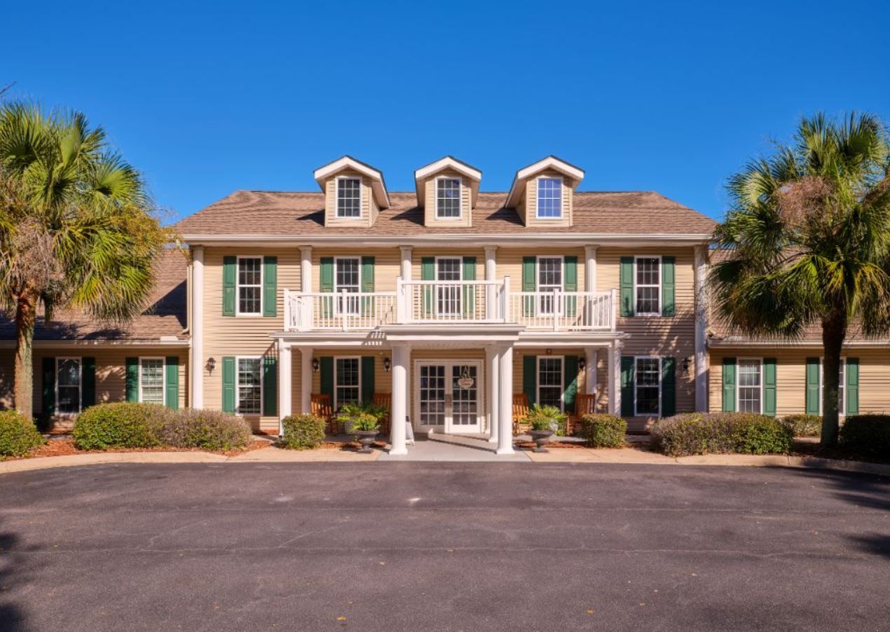 Front view of the Savannah Place facility with palm trees