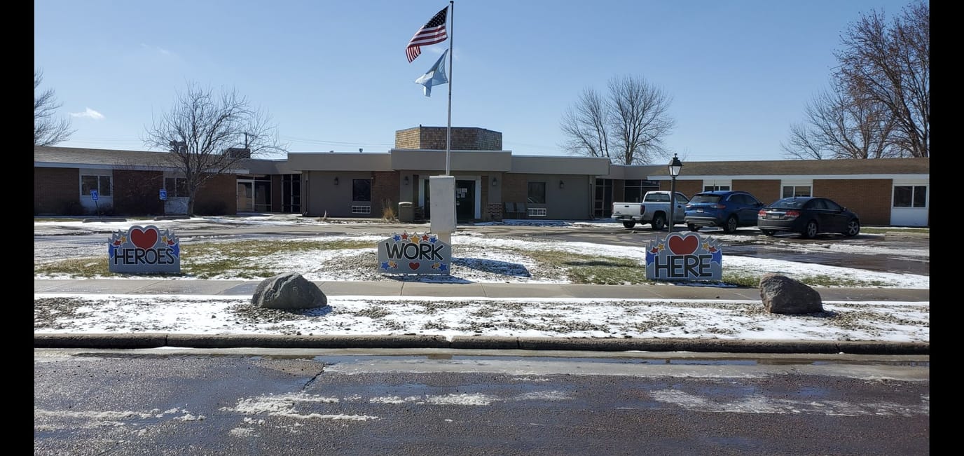 Exterior view of The Wellshire Huron with signs and flag