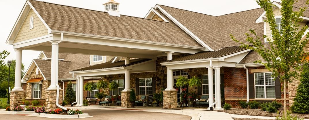 Front entrance of a senior living facility with a covered porch