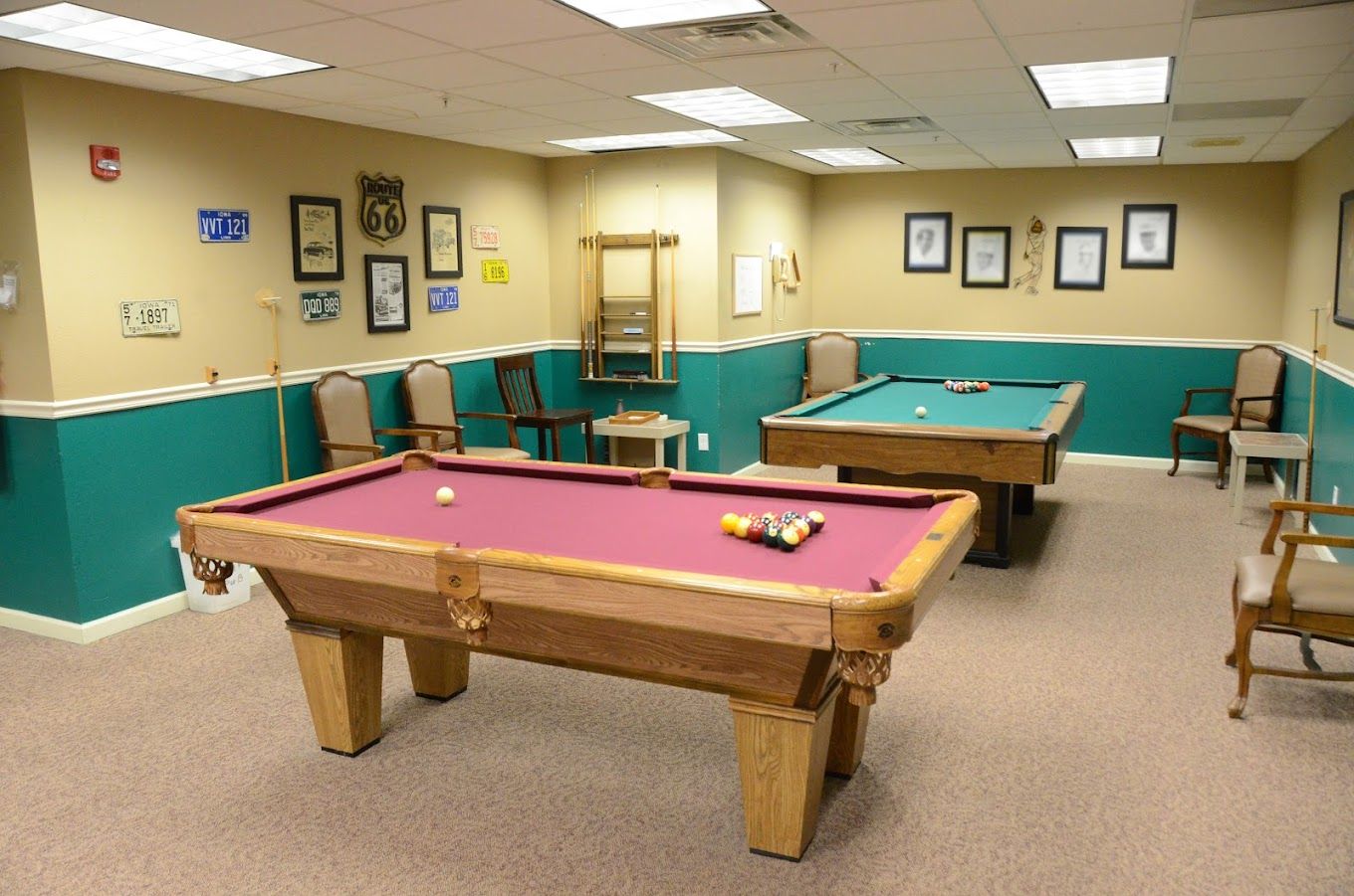 Billiards room with two pool tables and chairs