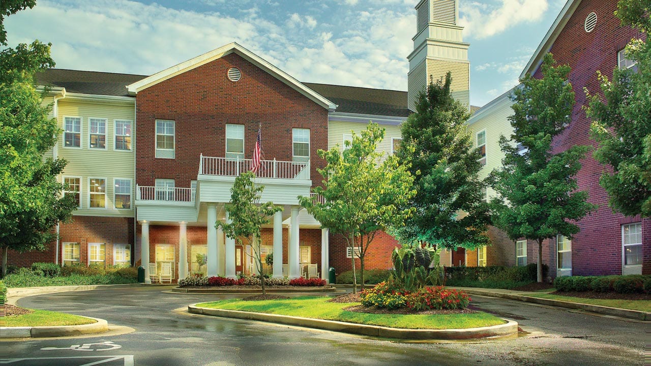 Front entrance of a senior living facility with landscaped gardens