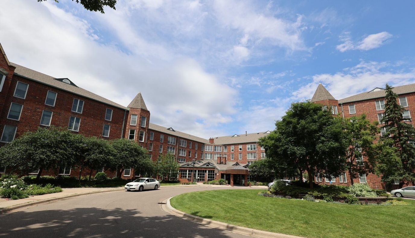 Exterior view of a senior living facility surrounded by greenery