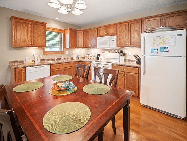 Bright kitchen area with wooden cabinets and dining table