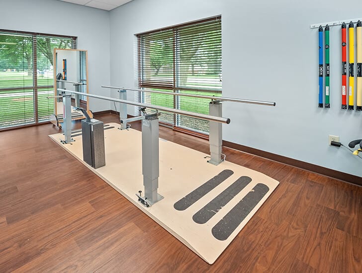 Physical therapy area with balance bars and equipment