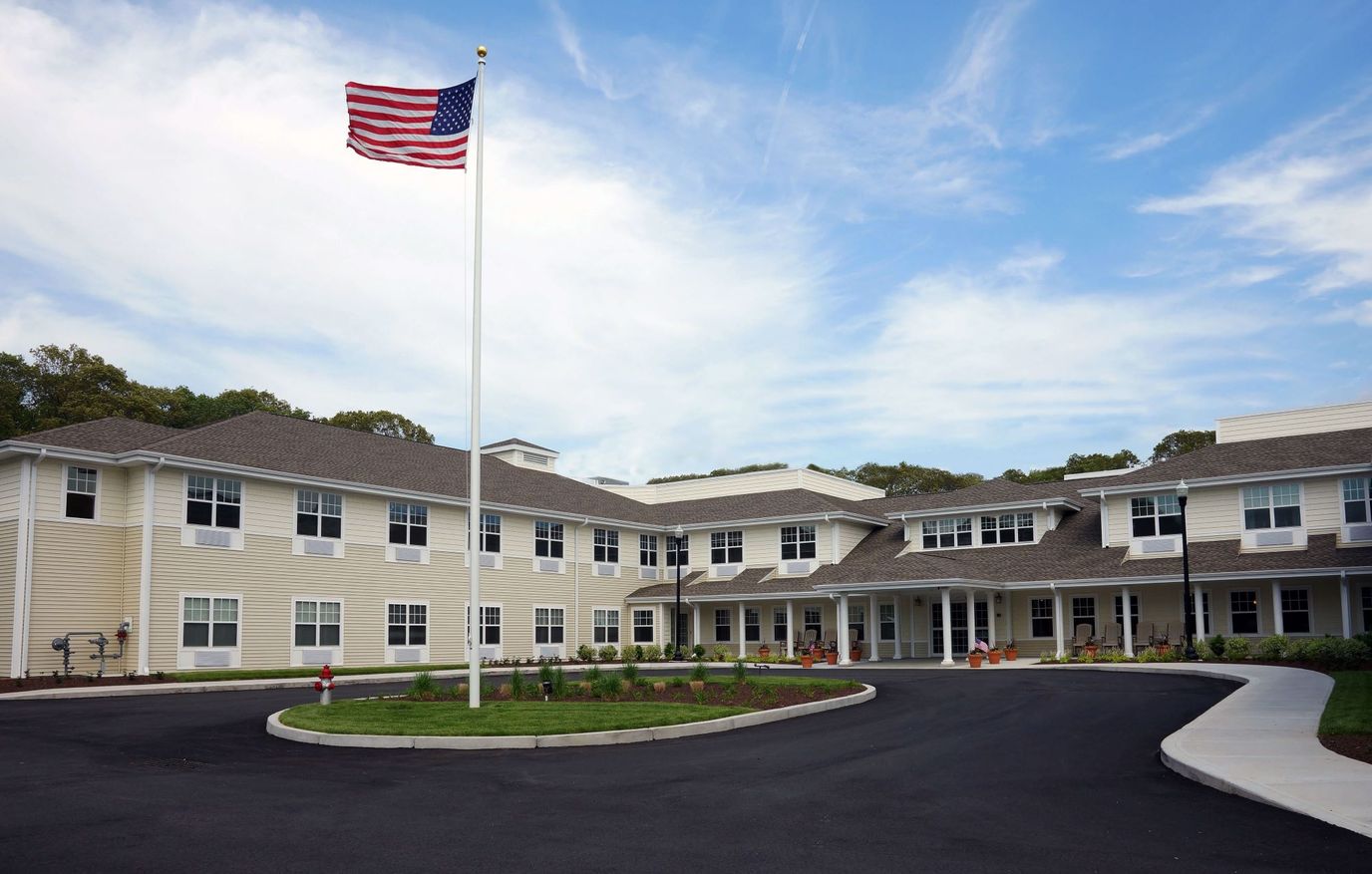 Exterior view of a senior living facility with flag