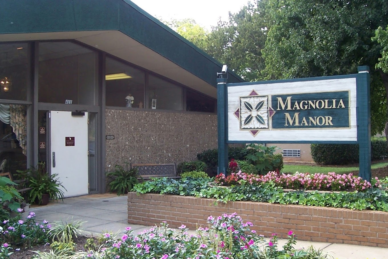 Exterior view of Magnolia Manor with floral landscaping