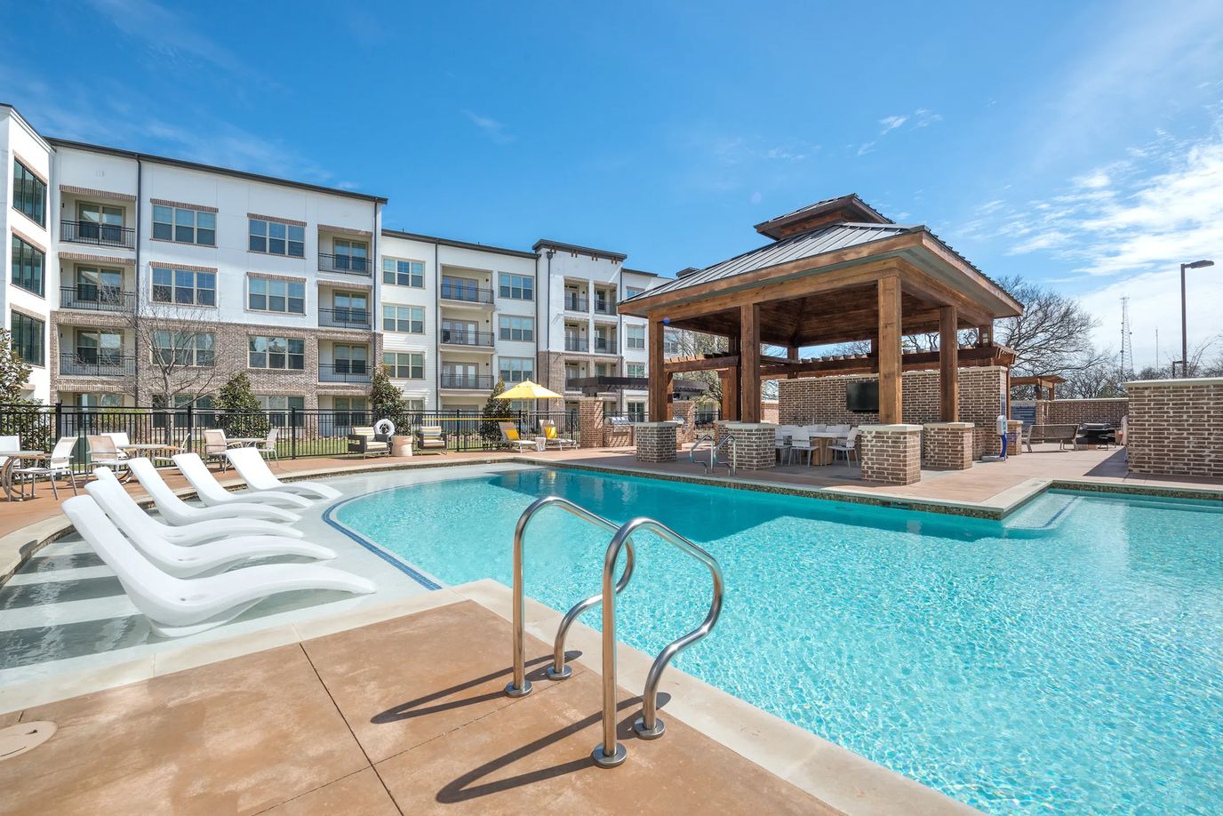 Outdoor pool area with seating and a pergola