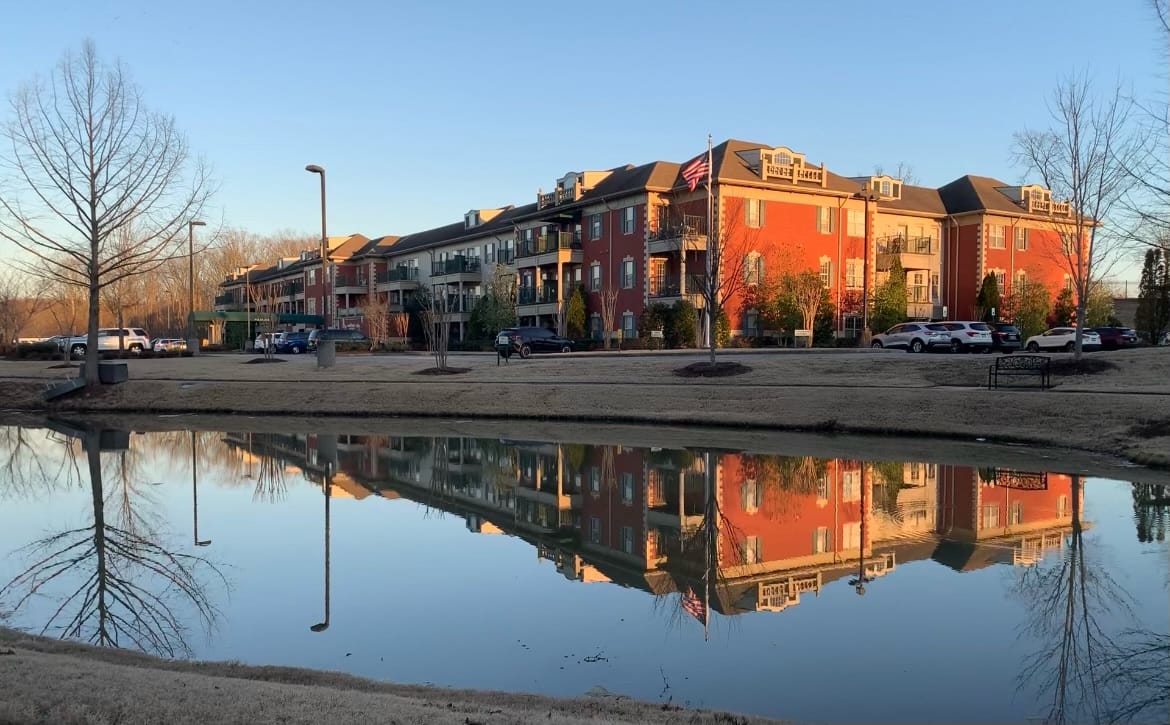 Exterior view of Silvercreek Senior Living by a pond