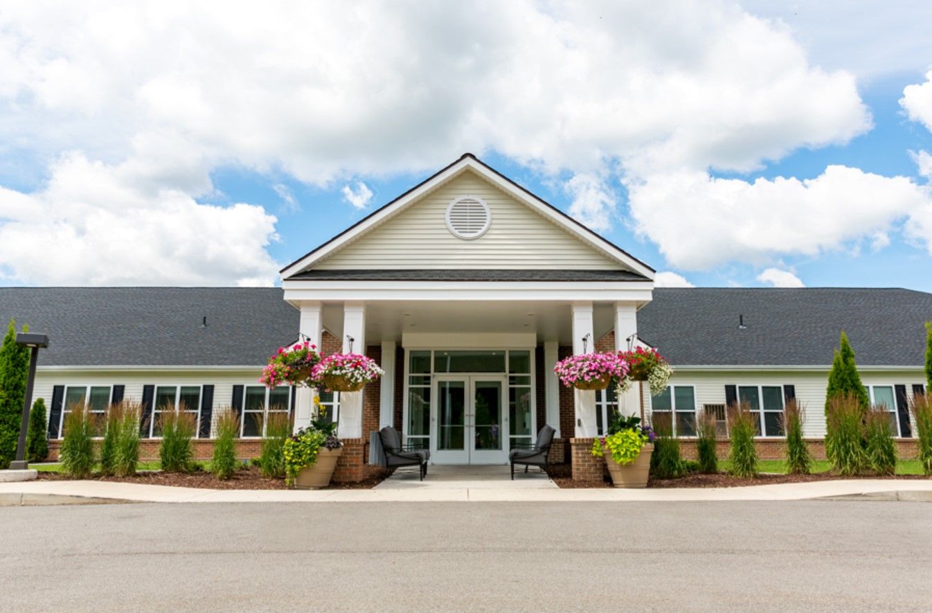 Entrance of a senior living facility with colorful flower planters