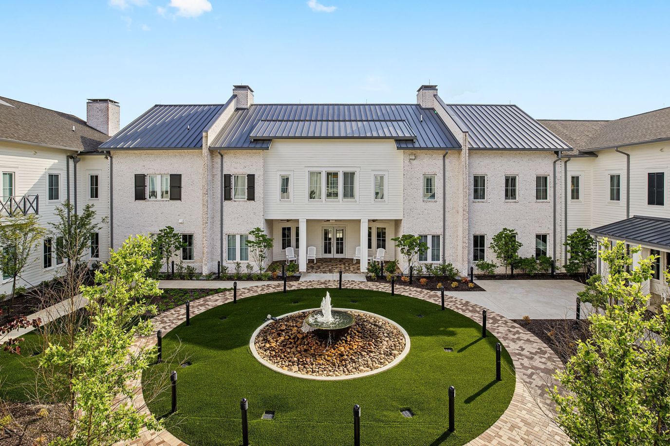 Exterior view of a senior living facility with a courtyard fountain