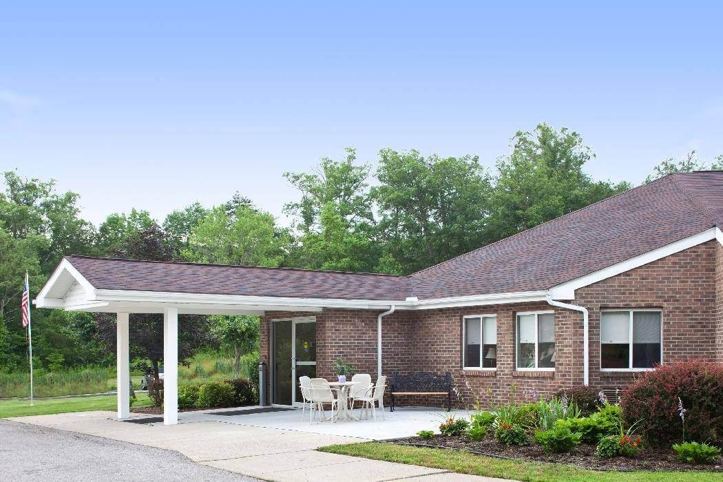 Exterior view of a senior living facility with outdoor seating