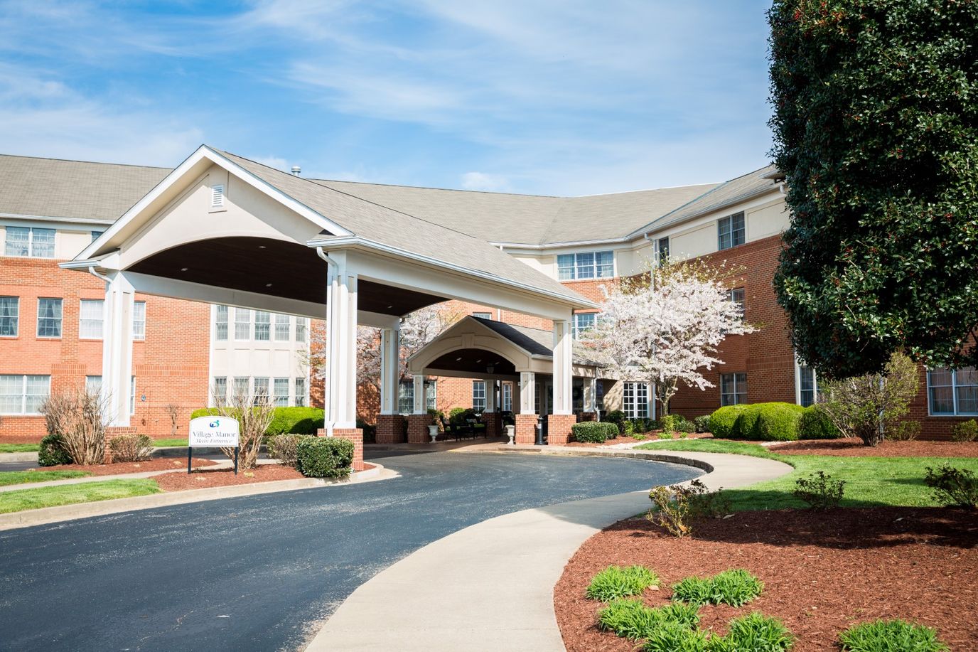 Front entrance of Village Manor with landscaped approach