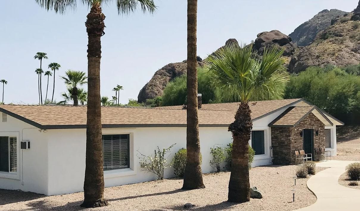 View of a single-story assisted living facility with palm trees