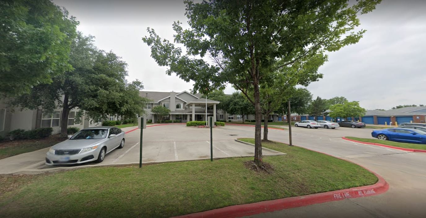 Exterior view of a senior living facility with parking