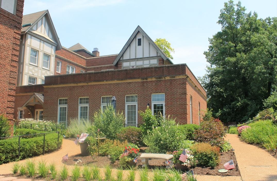Exterior view of a senior living facility with gardens