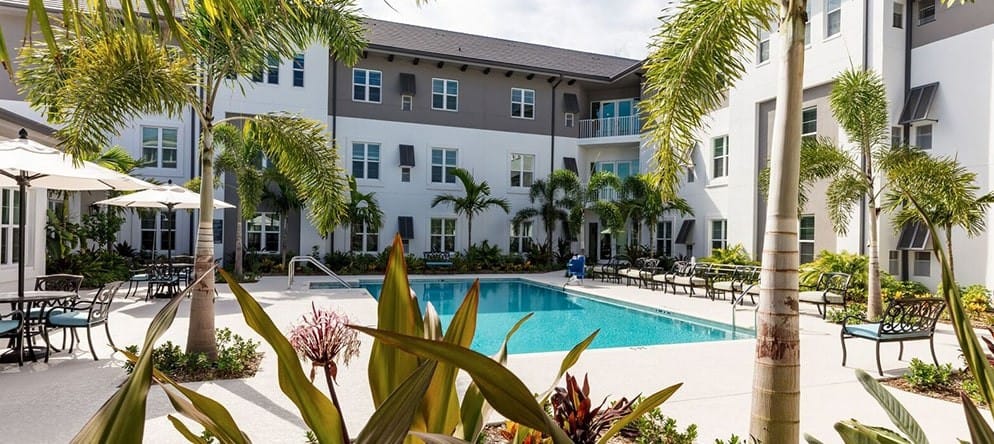 Outdoor pool area with seating and palm trees