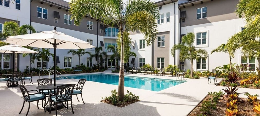 Outdoor pool area with seating and palm trees