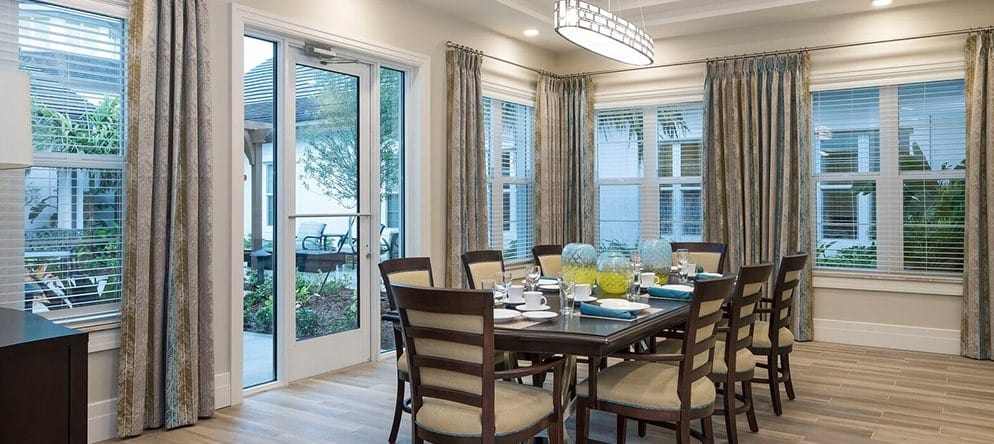 Bright dining room with large windows and tables set for meals