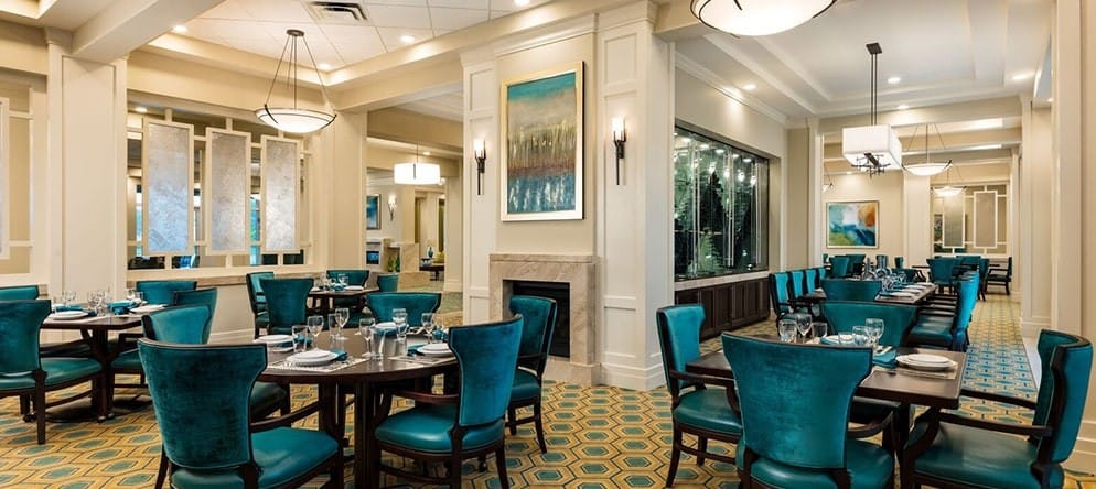 A well-set dining room with teal chairs and tables