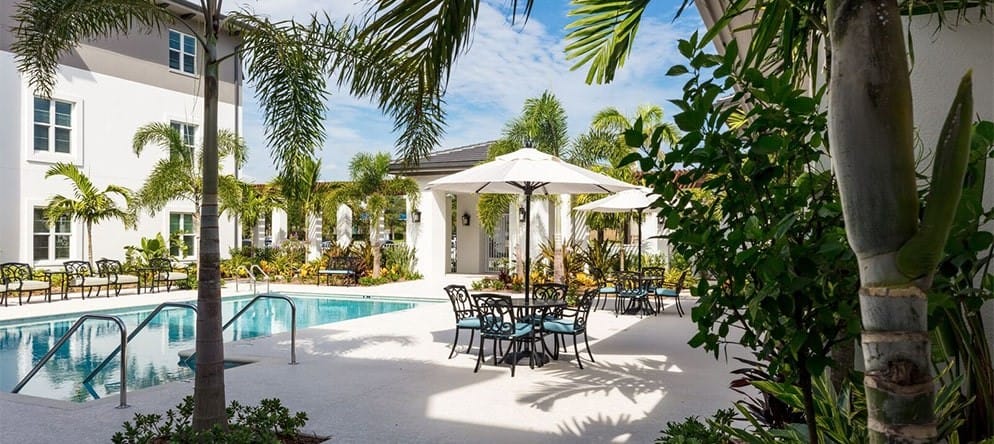 Outdoor pool area with seating and umbrellas