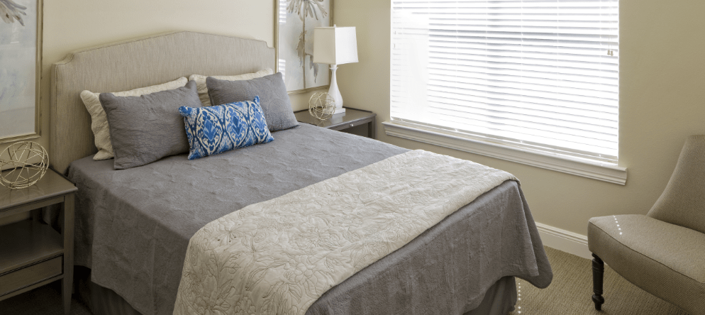 Cozy resident bedroom with a made bed and natural light