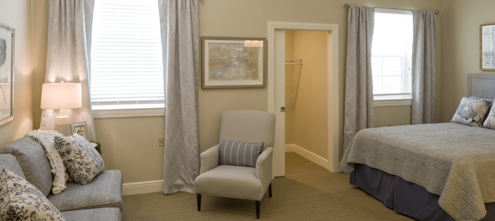 Brightly decorated private resident room with a bed and seating area