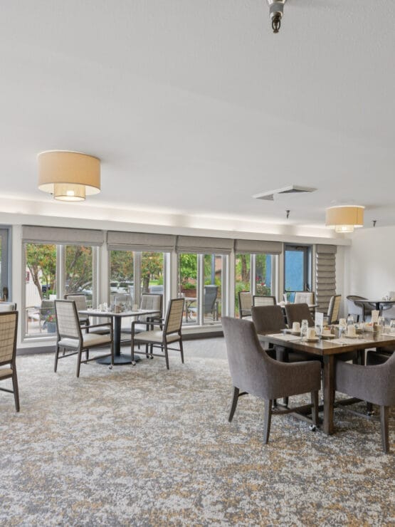 Brightly lit dining area with tables and chairs.