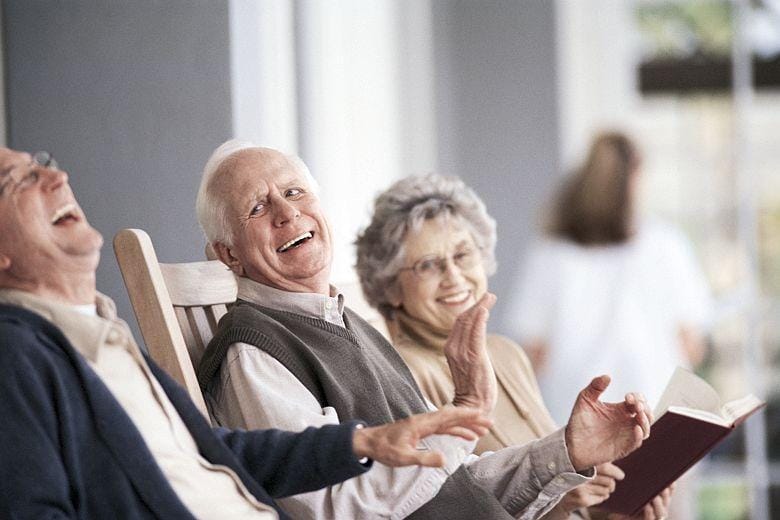 Azura Memory Care of Stoughton, assisted living in Stoughton, WI — Seniors enjoying laughter and conversation in rocking chairs
