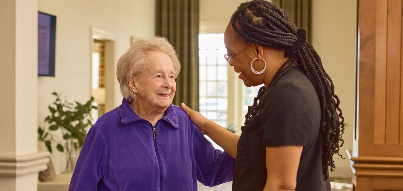 A caregiver talking with an elderly resident