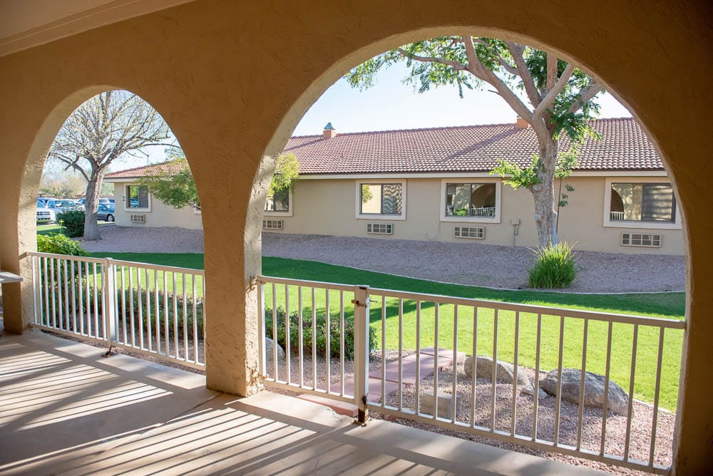 View of a landscaped courtyard through arched outdoor railings