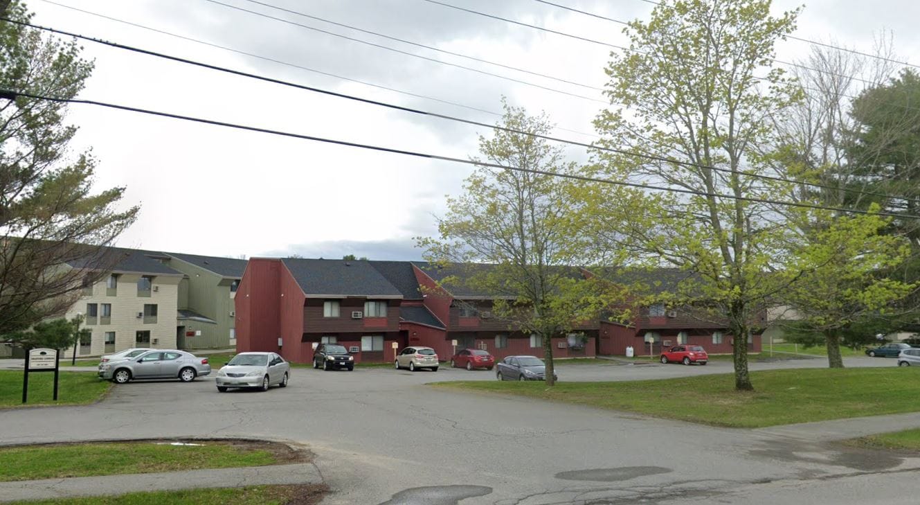 Exterior view of Bradford Commons facility with trees and parking