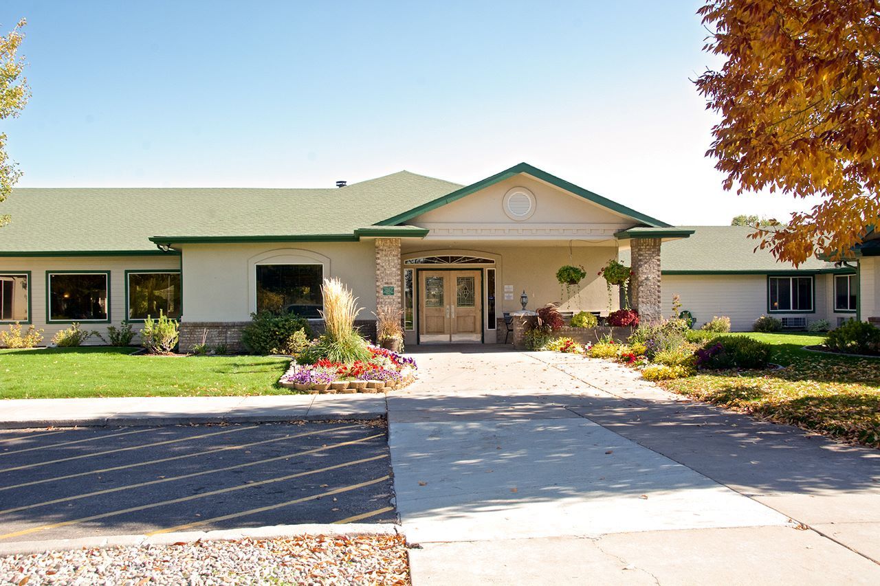 Exterior view of a senior living facility with gardens