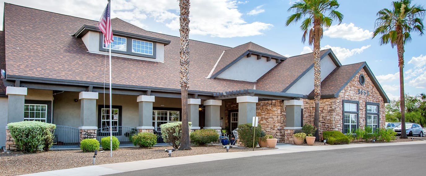 Exterior view of a senior living facility with palm trees