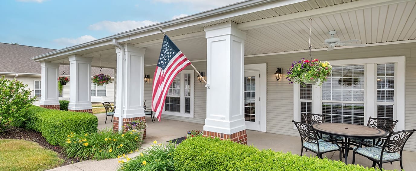 Front porch with American flag and flower pots