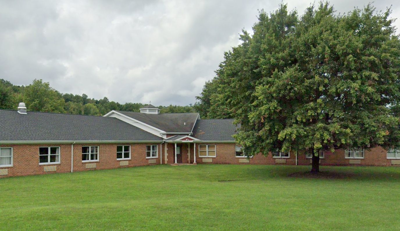 Exterior view of Fairview Retirement Community building with large tree