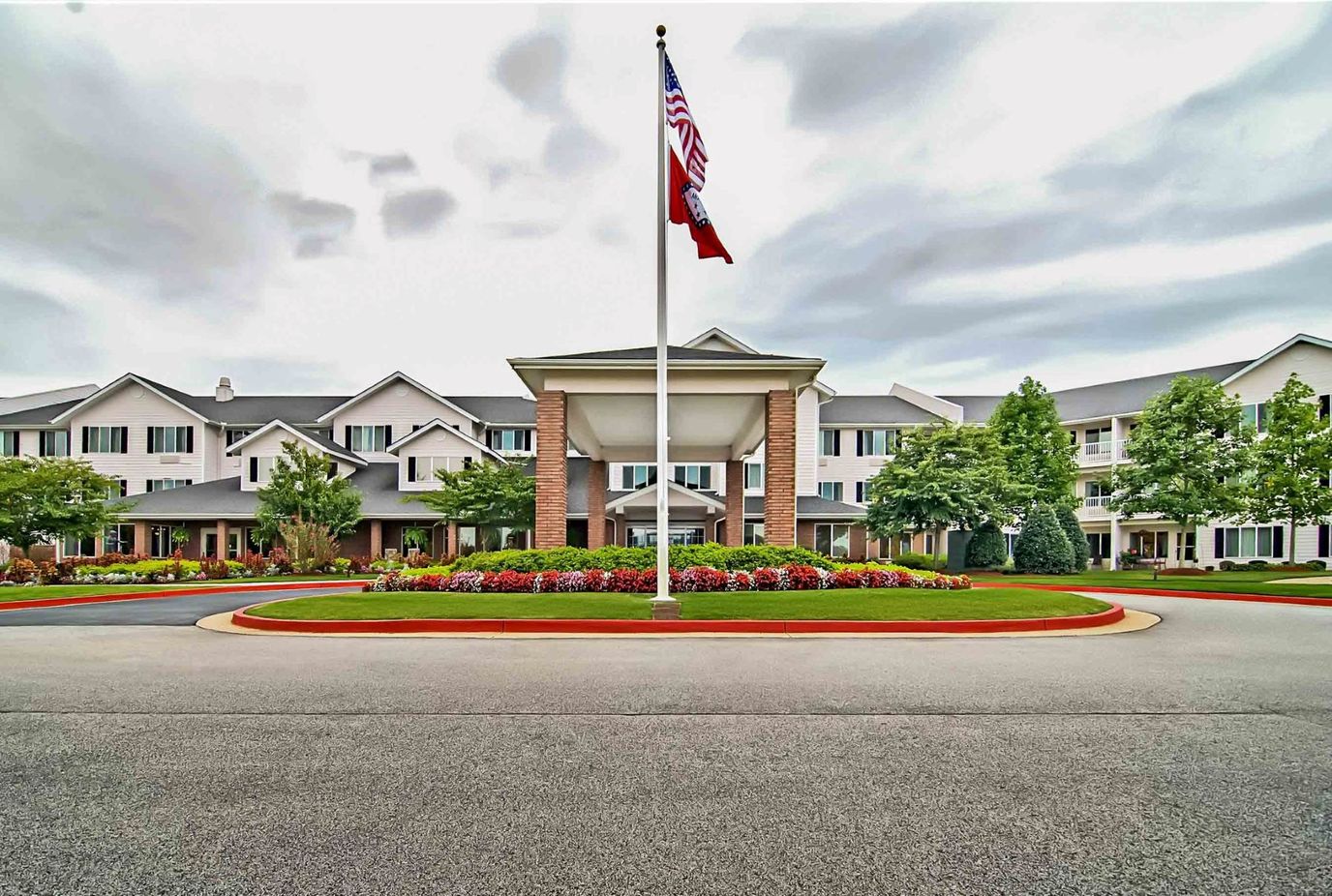 Front exterior of Morada Fort Smith with landscaping and flags